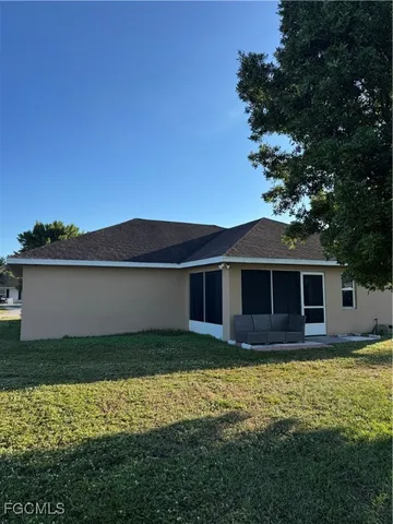 a front view of house with yard and trees in the background