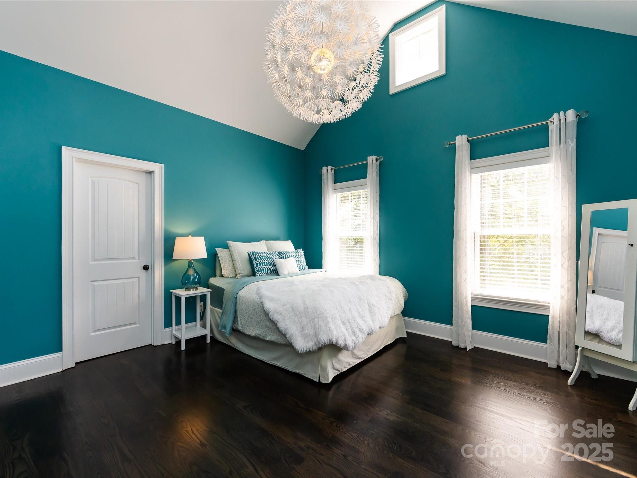 132 Chaska Loop Troutman, NC 28166 - Photo 27 of 48 a spacious bedroom with a bed and a chandelier