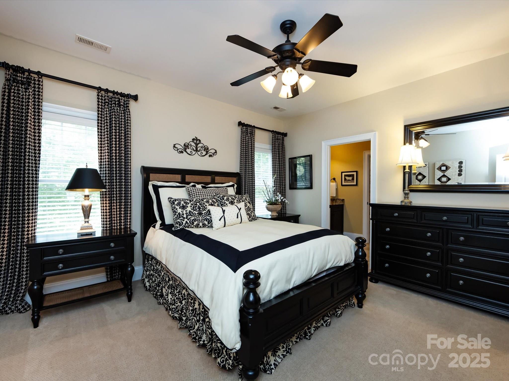 132 Chaska Loop Troutman, NC 28166 - Photo 29 of 48 a bedroom with a bed a dresser and paintings on the wall