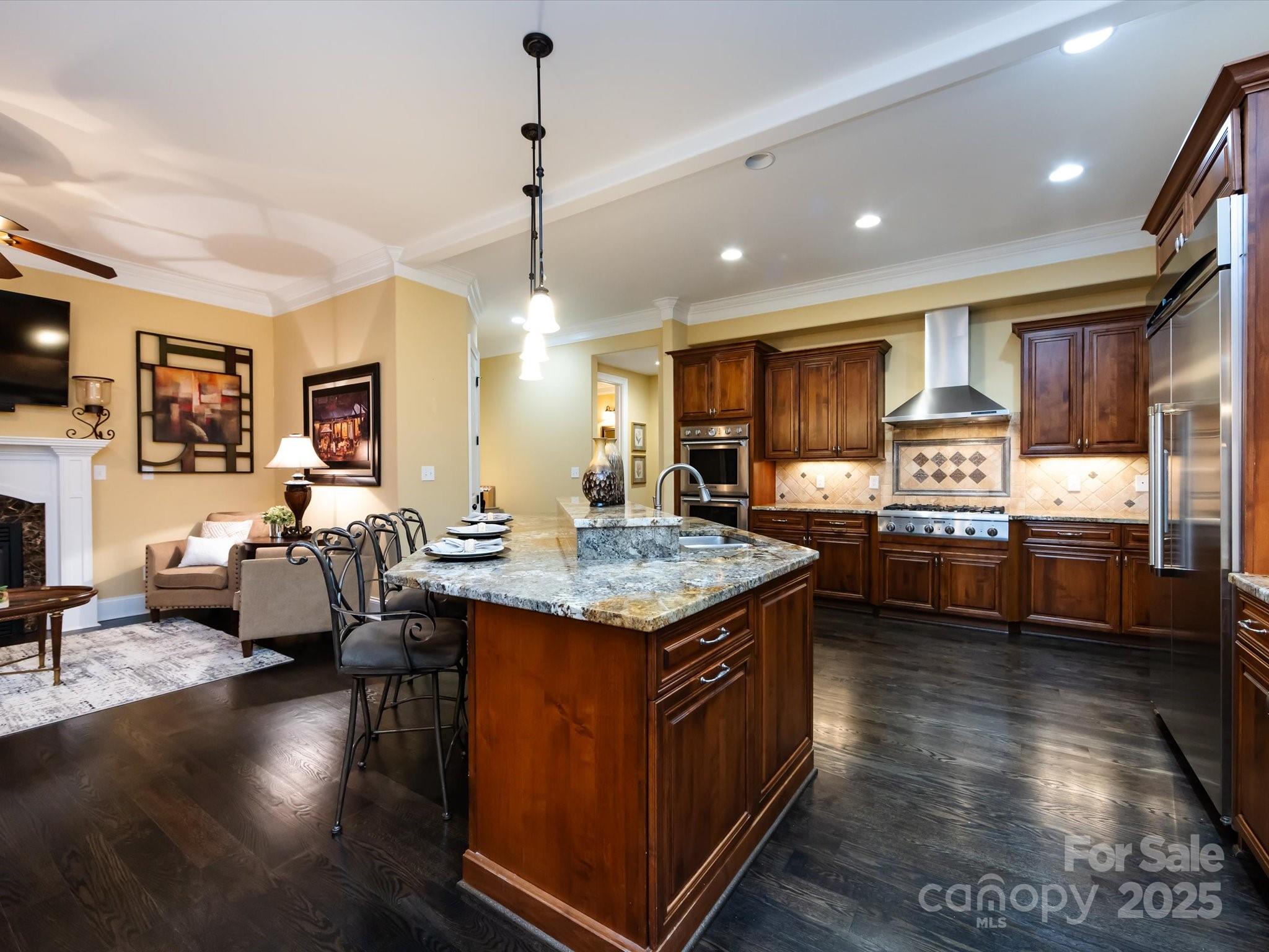 132 Chaska Loop Troutman, NC 28166 - Photo 6 of 48 a kitchen with granite countertop a stove top oven a dining table and chairs with wooden floor