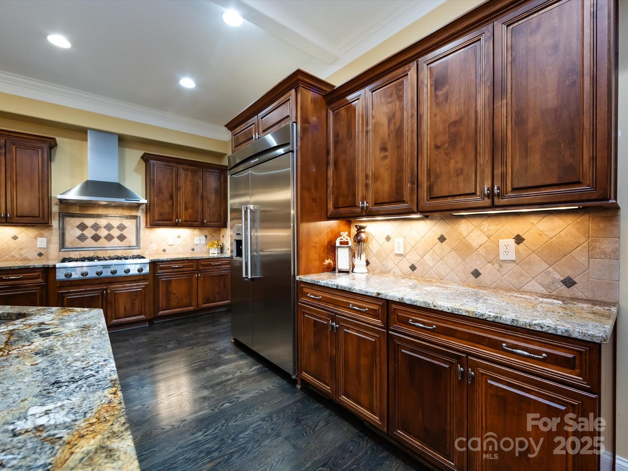 132 Chaska Loop Troutman, NC 28166 - Photo 7 of 48 a kitchen with granite countertop wooden cabinets and stainless steel appliances