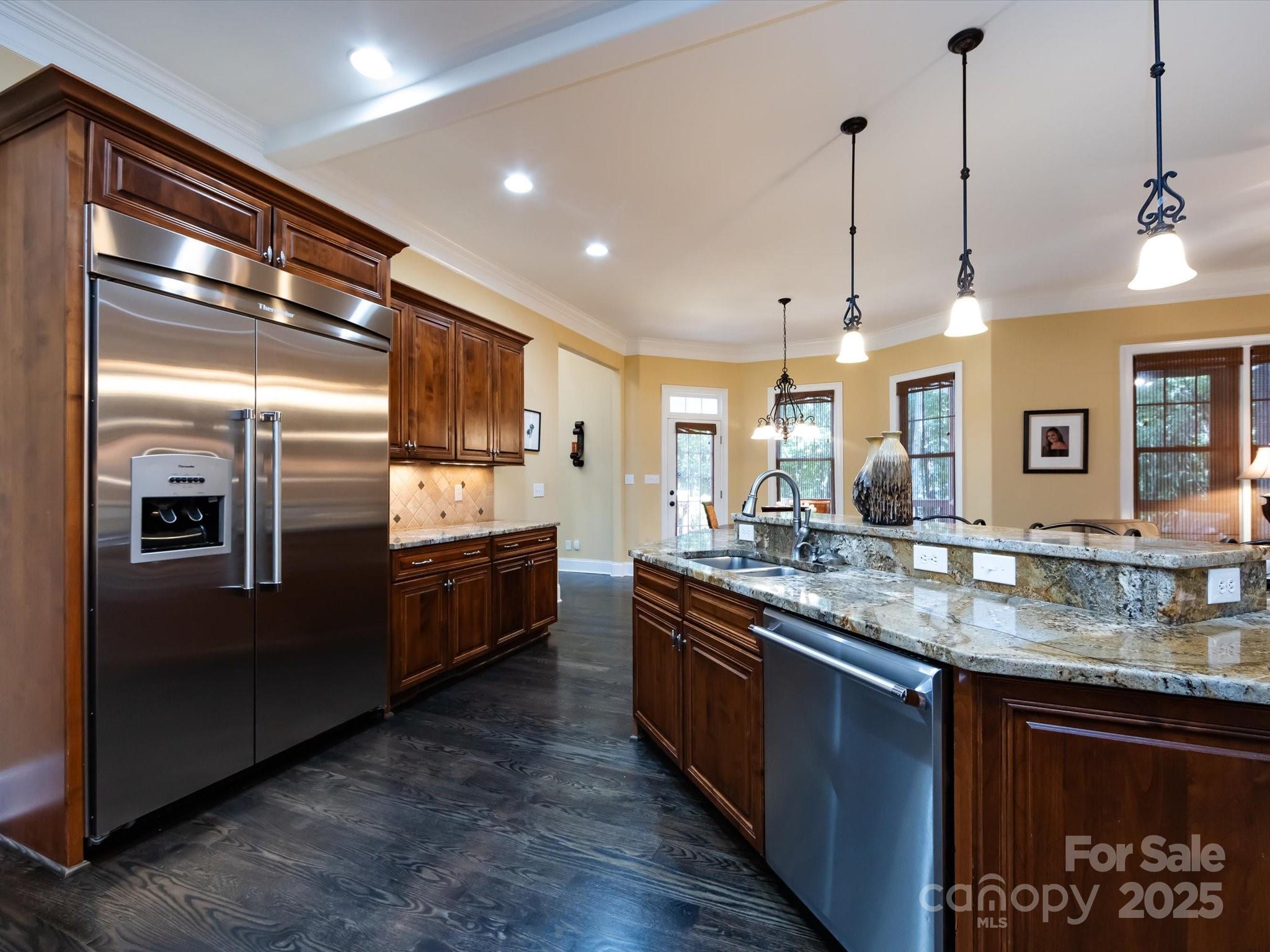 132 Chaska Loop Troutman, NC 28166 - Photo 9 of 48 a kitchen with stainless steel appliances granite countertop a refrigerator a sink and a wooden floor