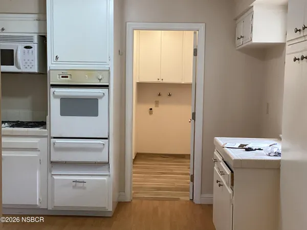 a kitchen with white cabinets and white appliances