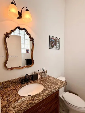 a bathroom with a granite countertop sink and a mirror