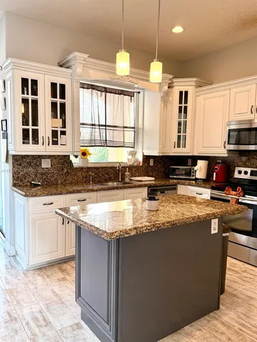 a kitchen with stainless steel appliances granite countertop a stove a sink and a granite counter tops