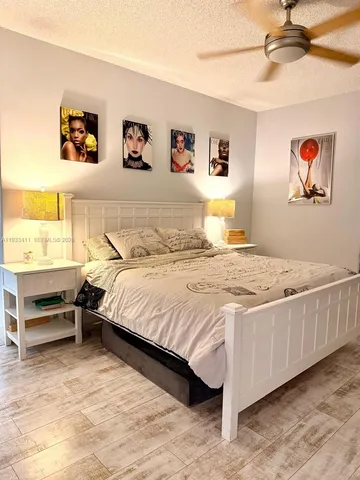 a large bedroom with a bed and flat screen tv
