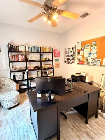 a view of a workspace with furniture and a window