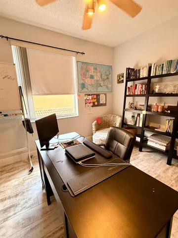 a living room with a bed furniture a chandelier and a flat screen tv