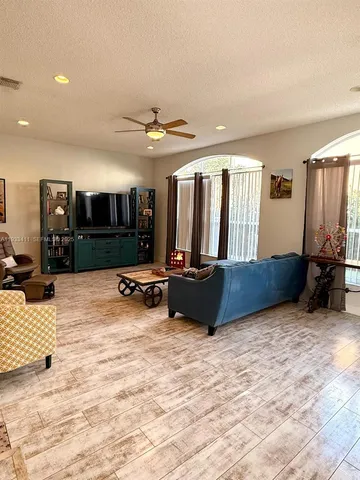 a living room with furniture a flat screen tv and a large window
