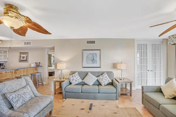 a living room with furniture kitchen view and a flat screen tv