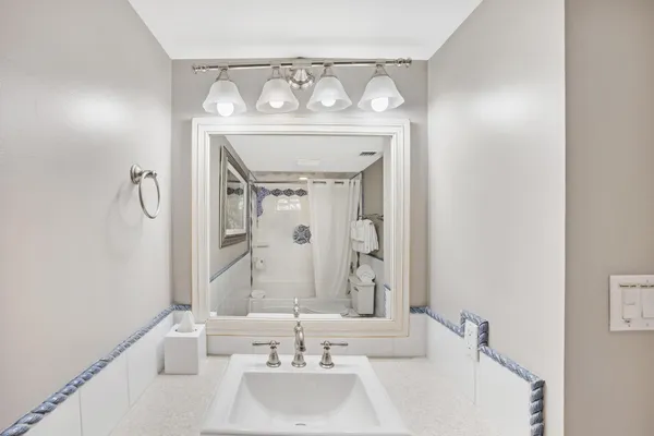 a bathroom with a granite countertop toilet sink and mirror