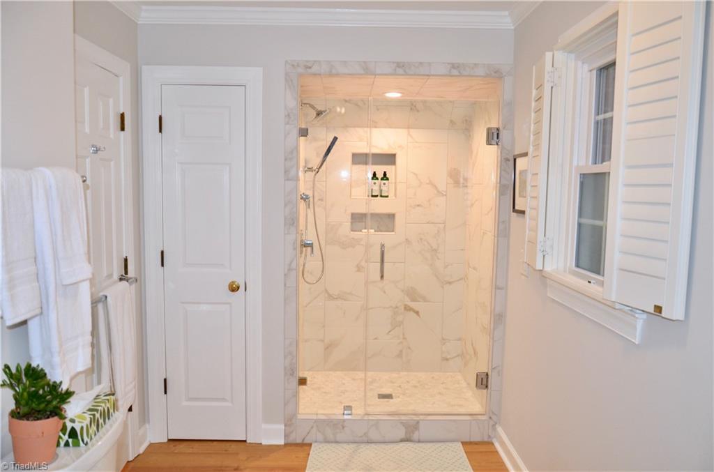 952 Bryanplace Road Winston-Salem, NC 27104 - Photo 19 of 30 Master bathroom renovated in 2020: tiled shower with Delta plumbing fixtures and sidebar sprayer, frameless glass door, Kohler toilet and LVP flooring.