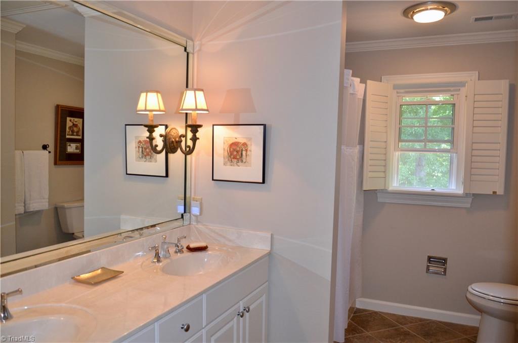 952 Bryanplace Road Winston-Salem, NC 27104 - Photo 24 of 30 Upstairs hall bathroom updates: versatile tile flooring, large taller-height vanity with double sinks, Kohler faucets, beveled mirror with added mirror mount lights in addition to 2020: replaced ceiling cans with LED lights and fresh paint. Toilet replaced 3-5 years ago. Large linen closet. Pulldown stairs-added new attic tent in 2020.