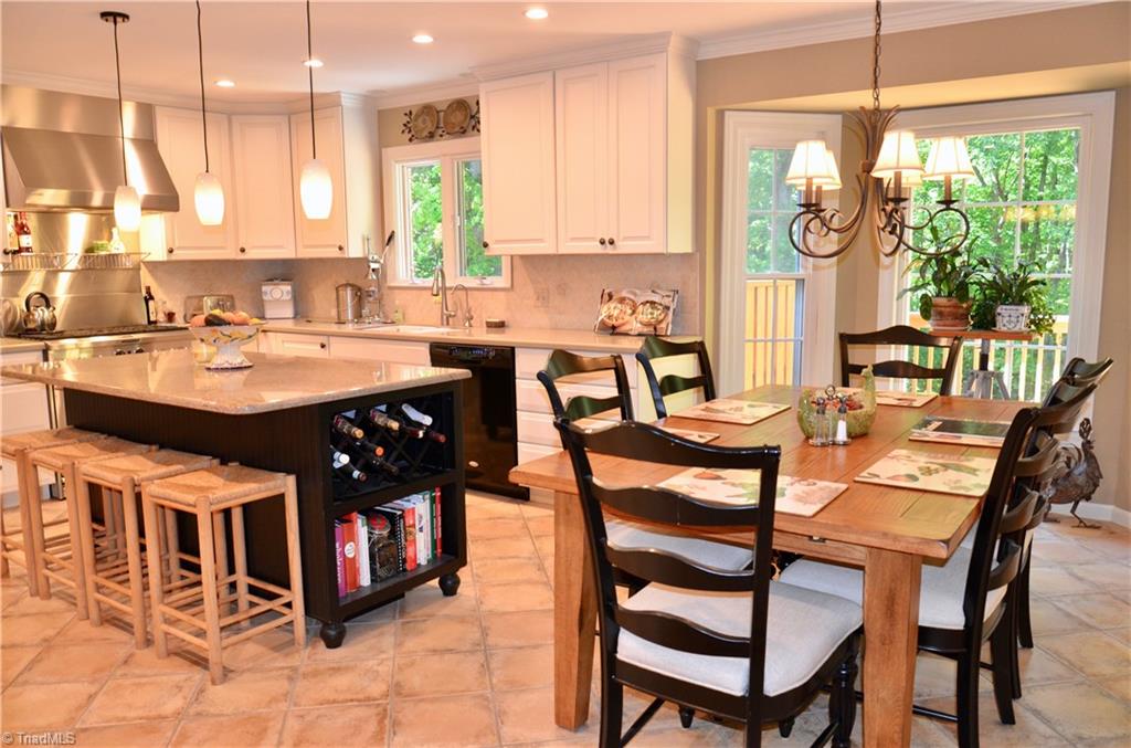 952 Bryanplace Road Winston-Salem, NC 27104 - Photo 6 of 30 Gourmet kitchen totally renovated: custom CWP wooden cabinets, KItchenAid dual fuel 6-burner stove, Thermador hood fan, wooden island cabinet with wine rack/cookbook nook, and granite countertop, tile floor, etc. 2019-2020: recessed lights replaced with LED lights, new sink faucet and RO water filtration system, ceiling paint and some fresh wall paint.