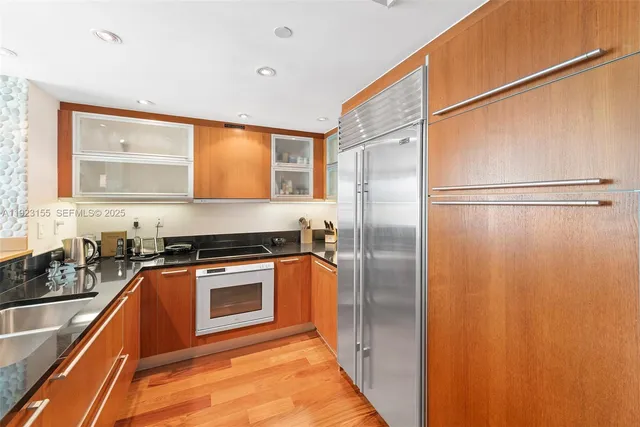 a kitchen with stainless steel appliances granite countertop a refrigerator and a sink