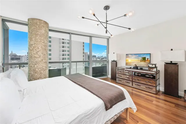 a bedroom with a large bed and a flat tv screen