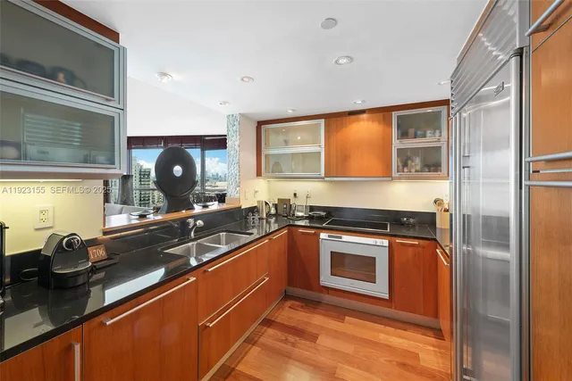 a kitchen with stainless steel appliances granite countertop a sink stove and refrigerator
