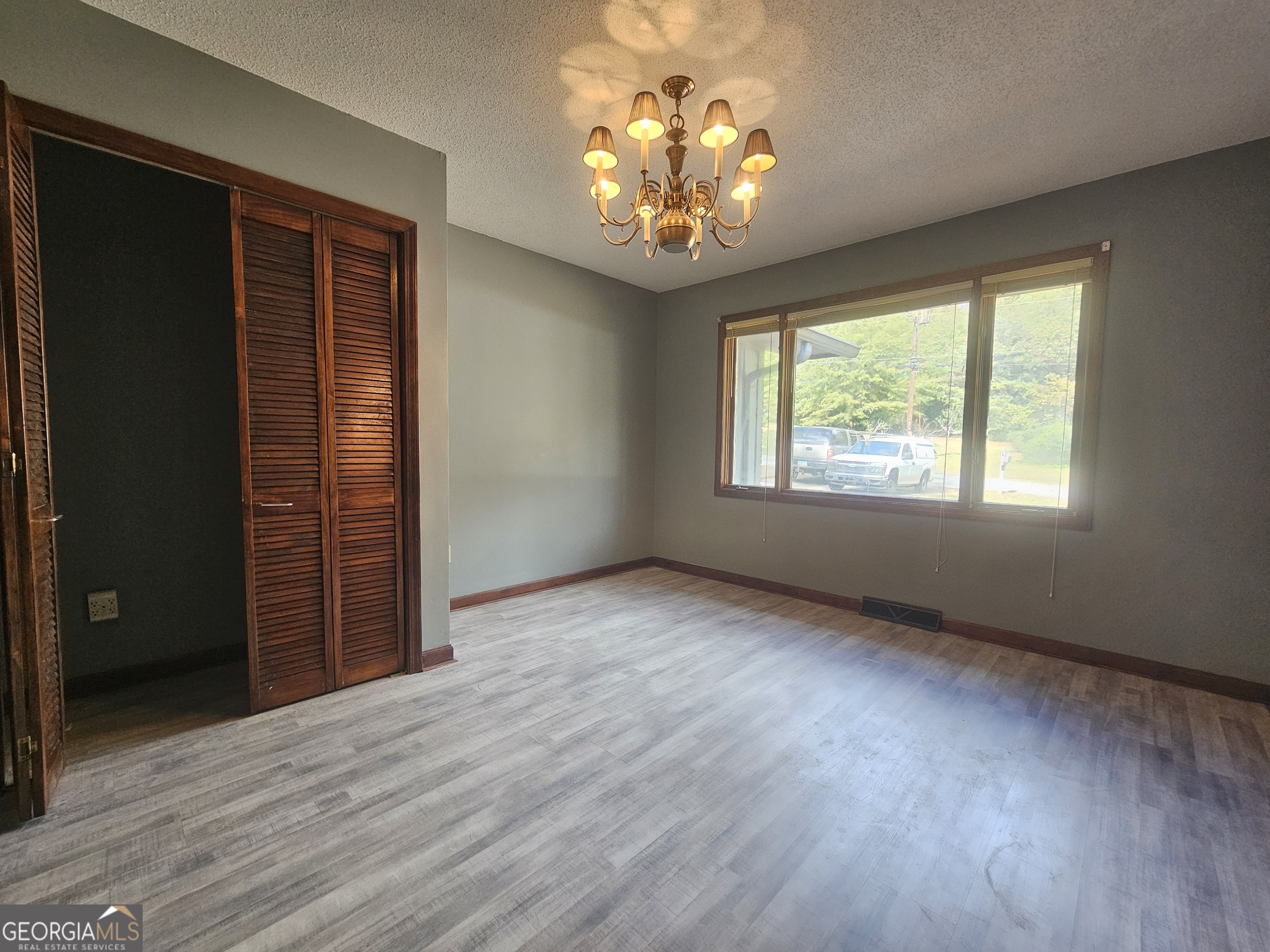 96 Glencrest Drive Toccoa, GA 30577 - Photo 11 of 15 an empty room with wooden floor chandelier and windows