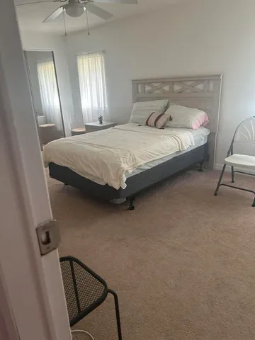 a bedroom with a bed chair and window