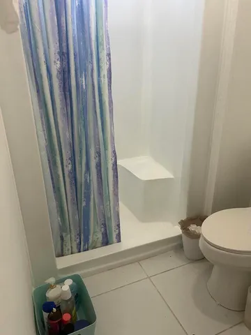 a bathroom with a toilet and a shower curtain