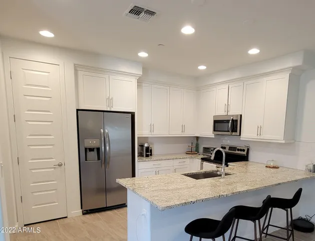 a kitchen with kitchen island a counter space a sink appliances and cabinets