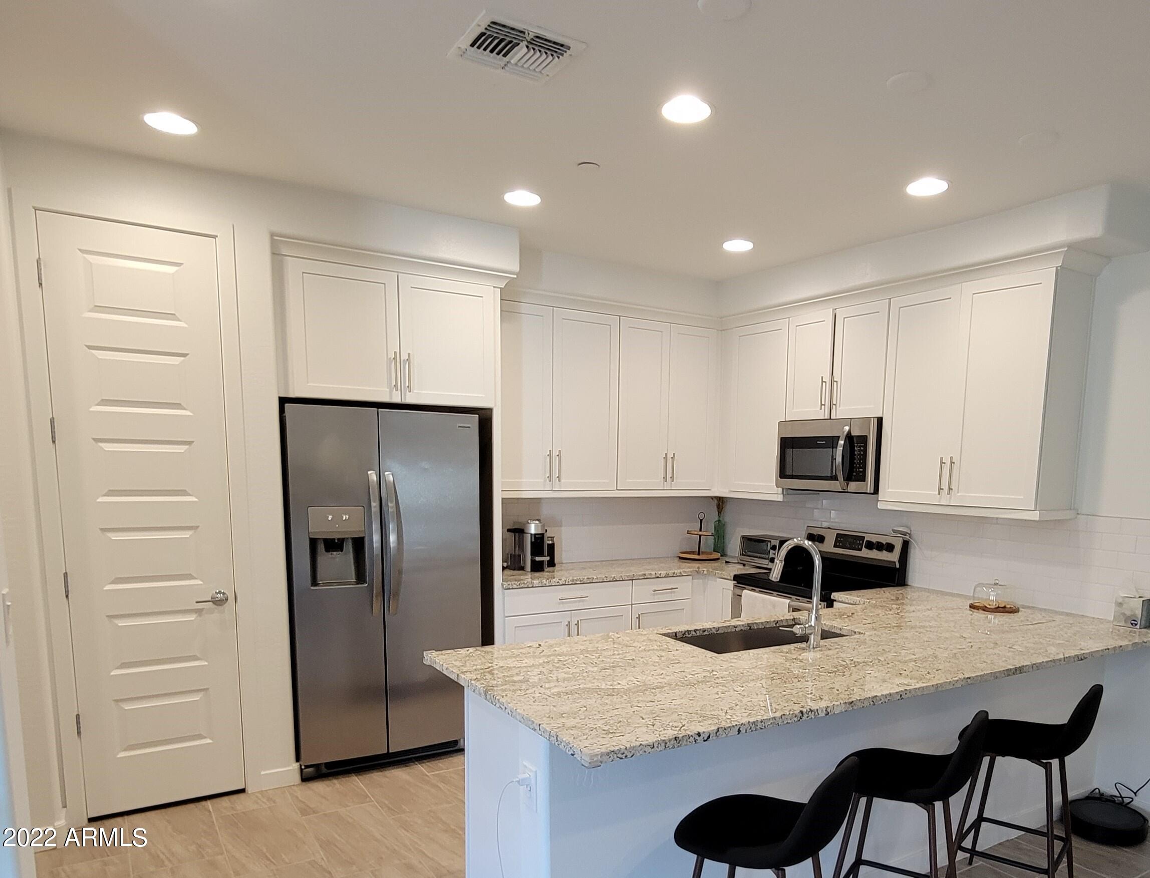 4100 South Pinelake Way, Unit 142 Chandler, AZ 85249 - Photo 12 of 25 a kitchen with kitchen island a counter space a sink appliances and cabinets