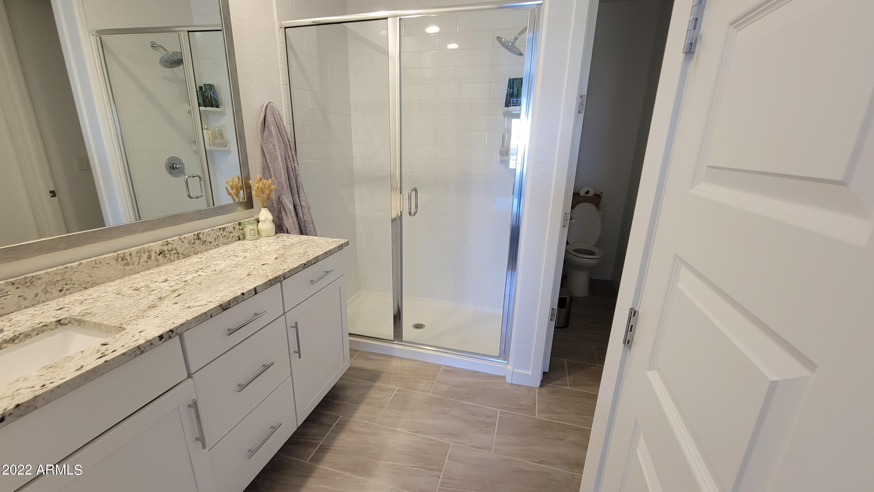 4100 South Pinelake Way, Unit 142 Chandler, AZ 85249 - Photo 17 of 25 a bathroom with a granite countertop sink a mirror and a shower