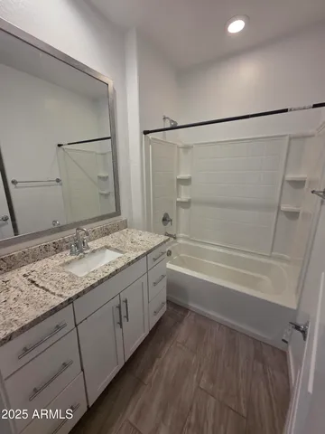 a bathroom with a granite countertop sink a toilet and shower