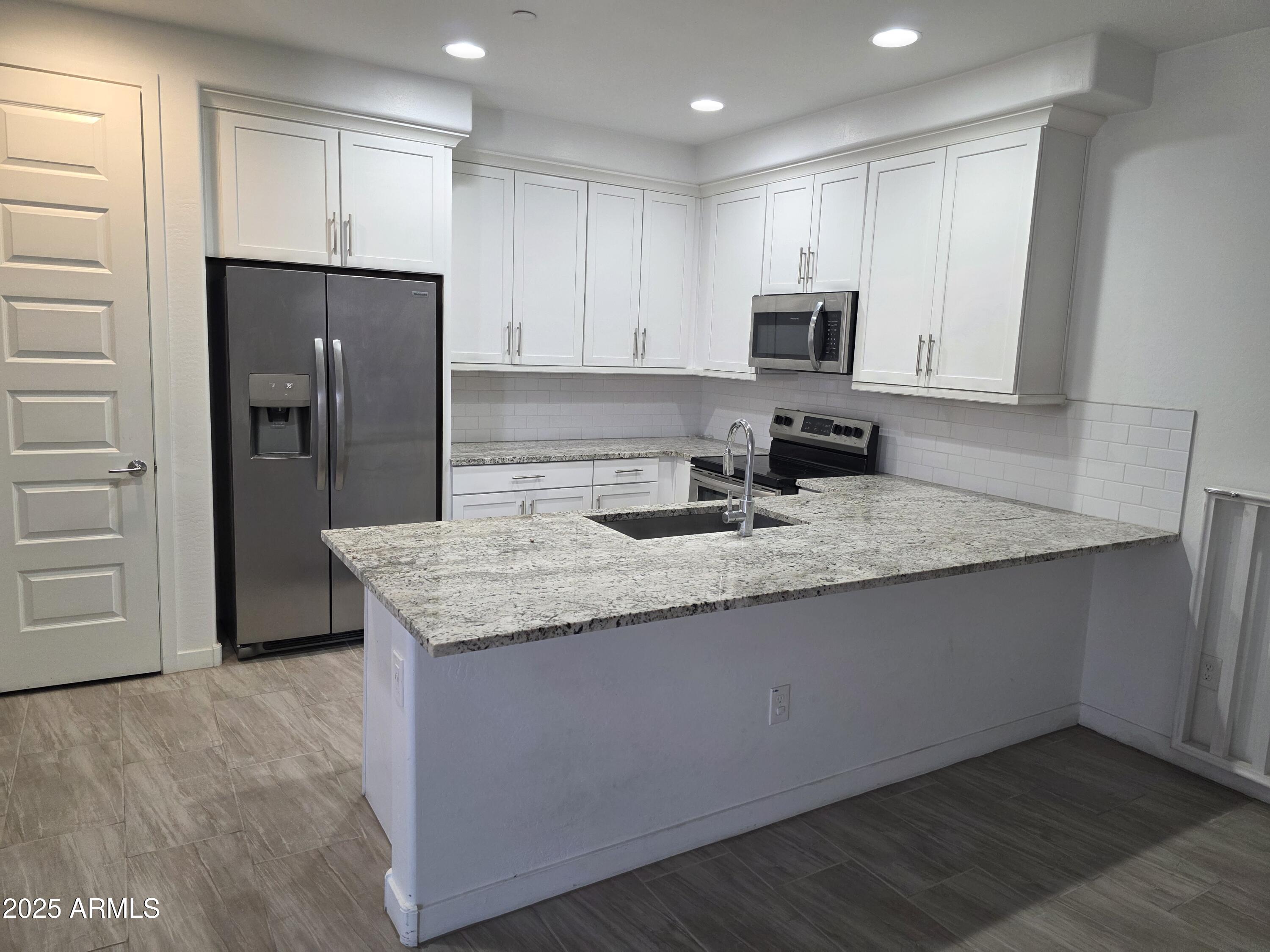 4100 South Pinelake Way, Unit 142 Chandler, AZ 85249 - Photo 5 of 25 a kitchen with stainless steel appliances granite countertop a refrigerator and a stove top oven