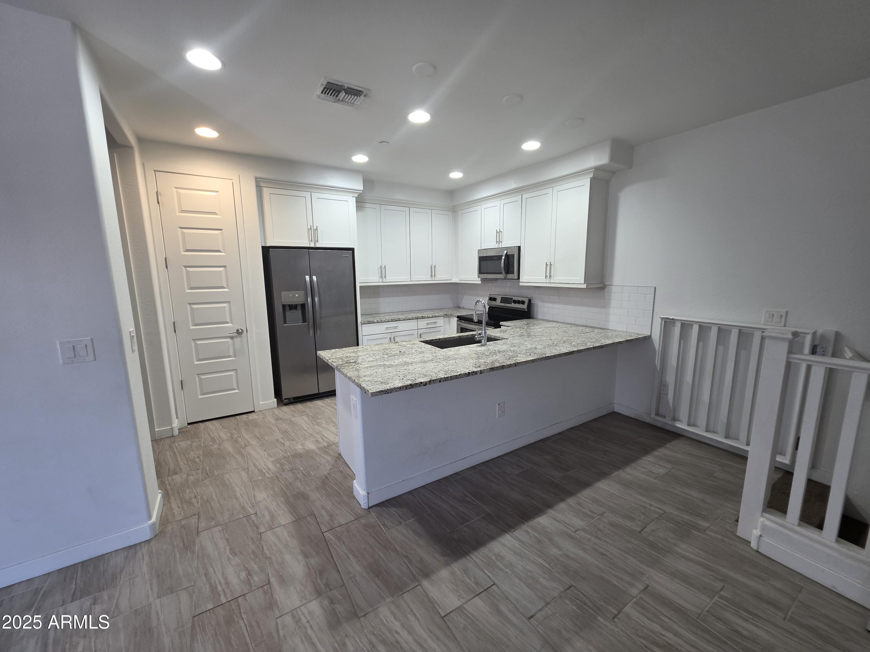 4100 South Pinelake Way, Unit 142 Chandler, AZ 85249 - Photo 7 of 25 a kitchen with stainless steel appliances granite countertop a refrigerator sink and wooden cabinets