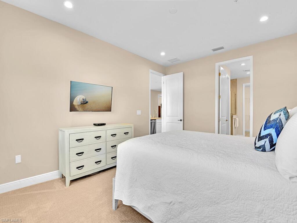 2561 Seychelles Drive, Unit 308 Naples, FL 34112 - Photo 12 of 28 a bedroom with a bed and a flat screen tv