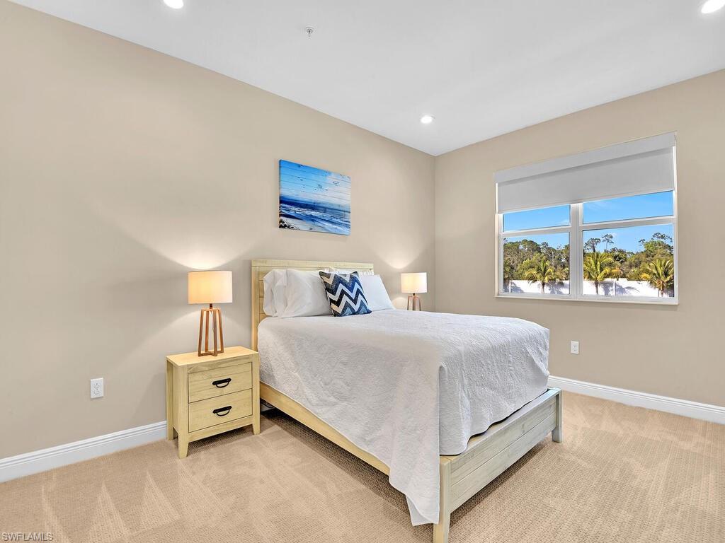 2561 Seychelles Drive, Unit 308 Naples, FL 34112 - Photo 13 of 28 a bedroom with a bed and painting on the wall