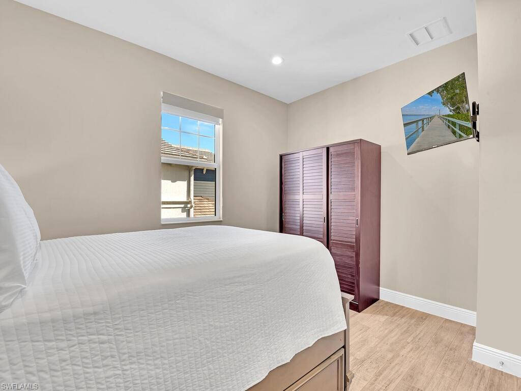 2561 Seychelles Drive, Unit 308 Naples, FL 34112 - Photo 16 of 28 a bedroom with a large bed and a window