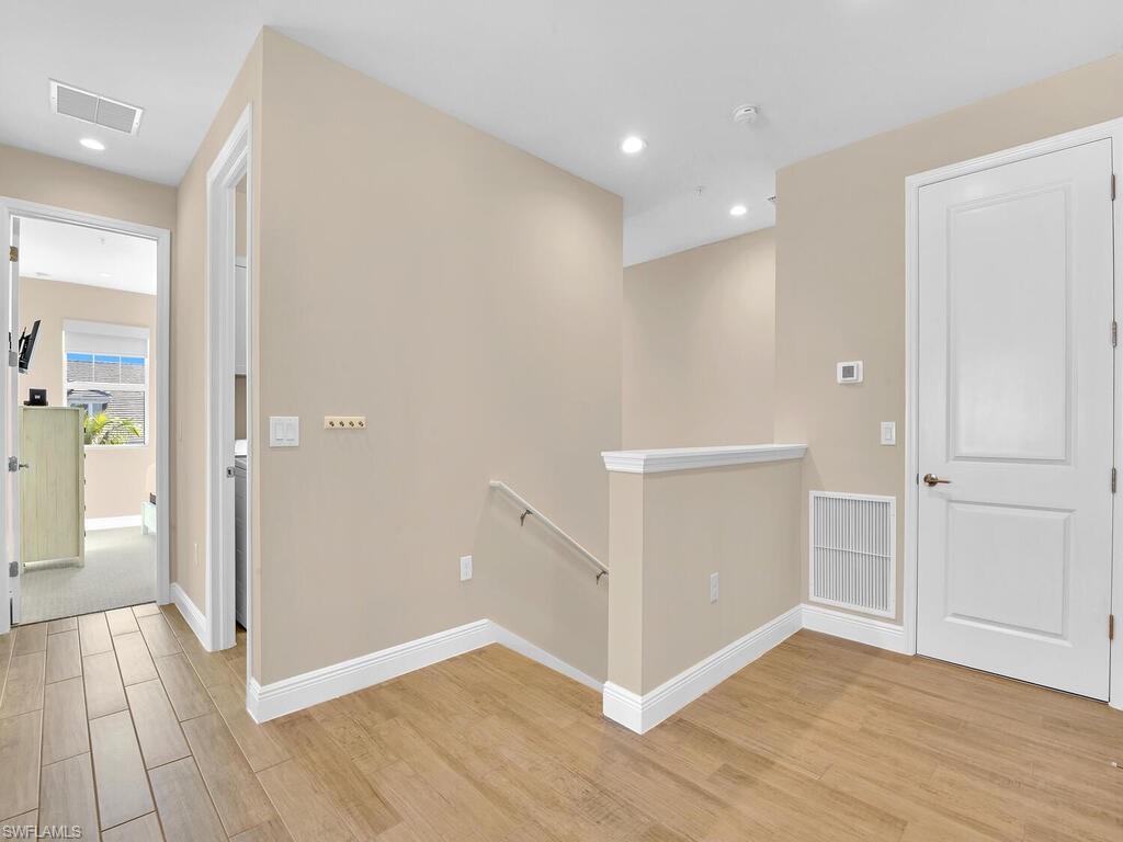 2561 Seychelles Drive, Unit 308 Naples, FL 34112 - Photo 19 of 28 wooden floor in an empty room with a window