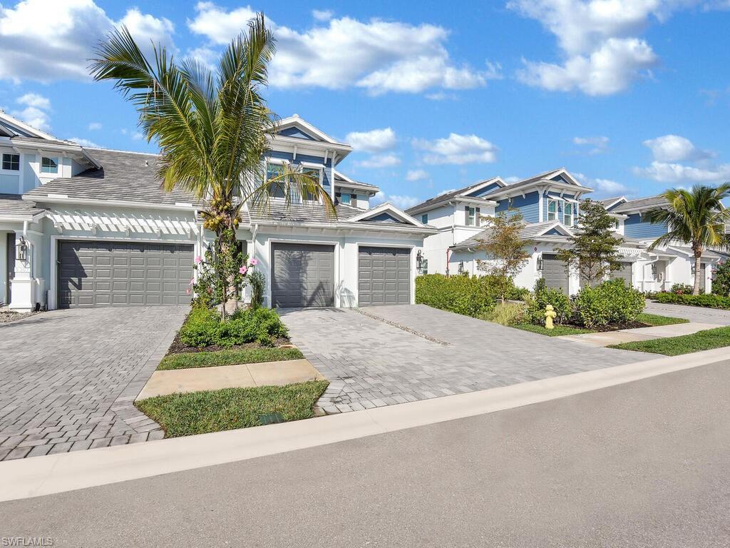 2561 Seychelles Drive, Unit 308 Naples, FL 34112 - Photo 22 of 28 a front view of a house with a yard and potted plants