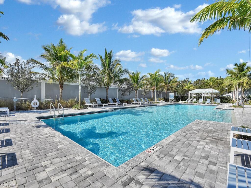 2561 Seychelles Drive, Unit 308 Naples, FL 34112 - Photo 25 of 28 a swimming pool with outdoor seating and yard