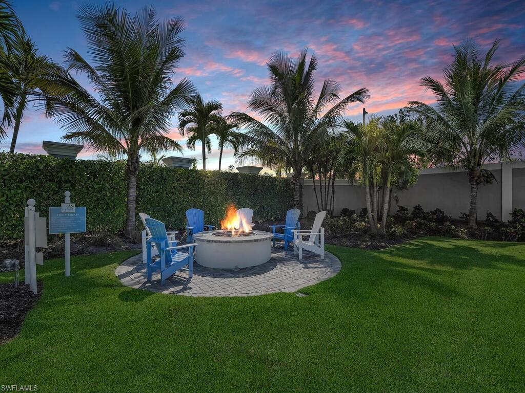 2561 Seychelles Drive, Unit 308 Naples, FL 34112 - Photo 28 of 28 a view of a backyard with table and chairs and a fire pit