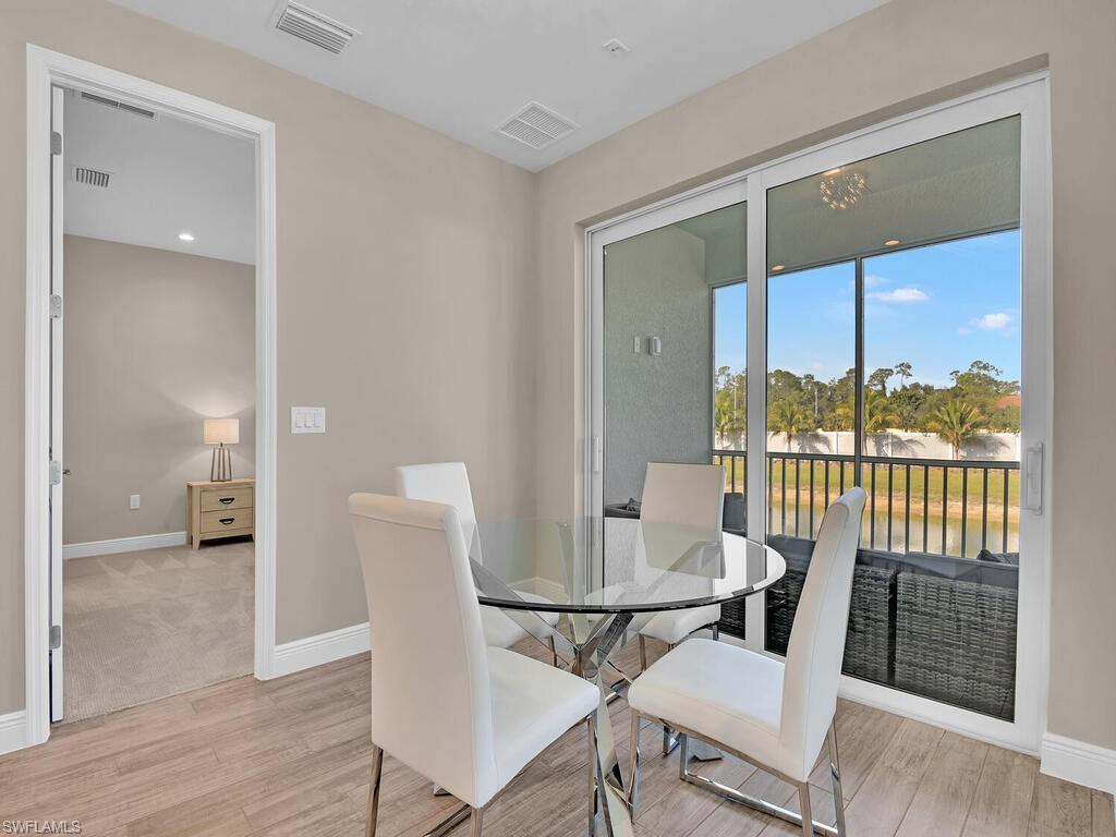 2561 Seychelles Drive, Unit 308 Naples, FL 34112 - Photo 8 of 28 a view of a dining room with furniture window and wooden floor