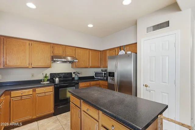 a kitchen with stainless steel appliances granite countertop a sink a stove and refrigerator