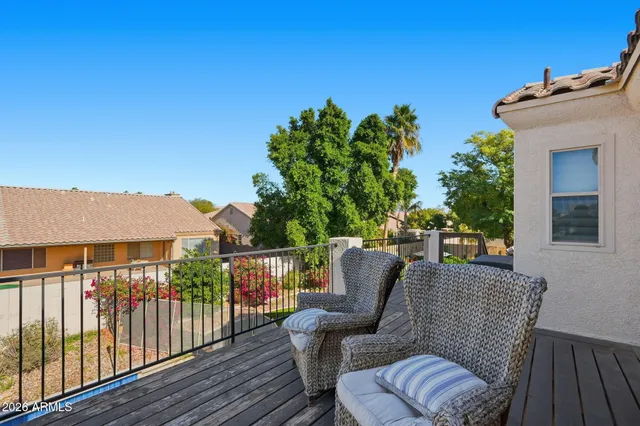 a balcony with wooden floor table and chairs