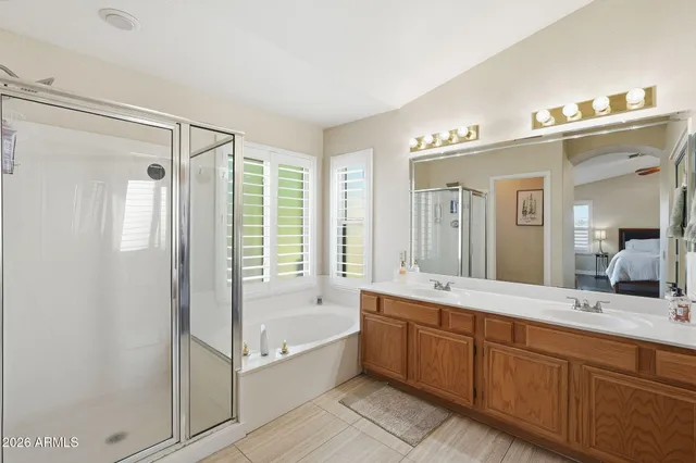 a spacious bathroom with a tub shower double sink and mirror
