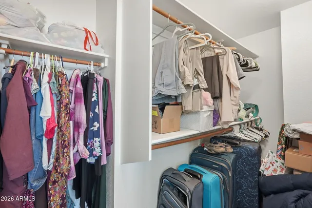 a view of walk in closet with clothes and shoes
