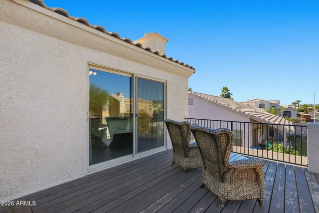 a view of a roof deck with table and chairs with wooden floor and fence