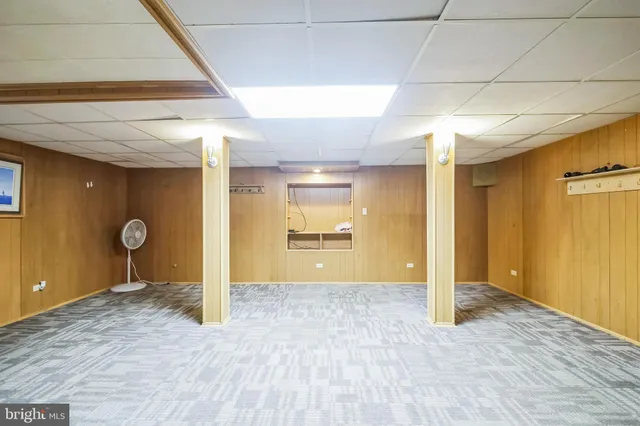 a view of an empty room with wooden floor and a bathroom