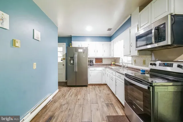 a kitchen with stainless steel appliances a refrigerator sink and microwave