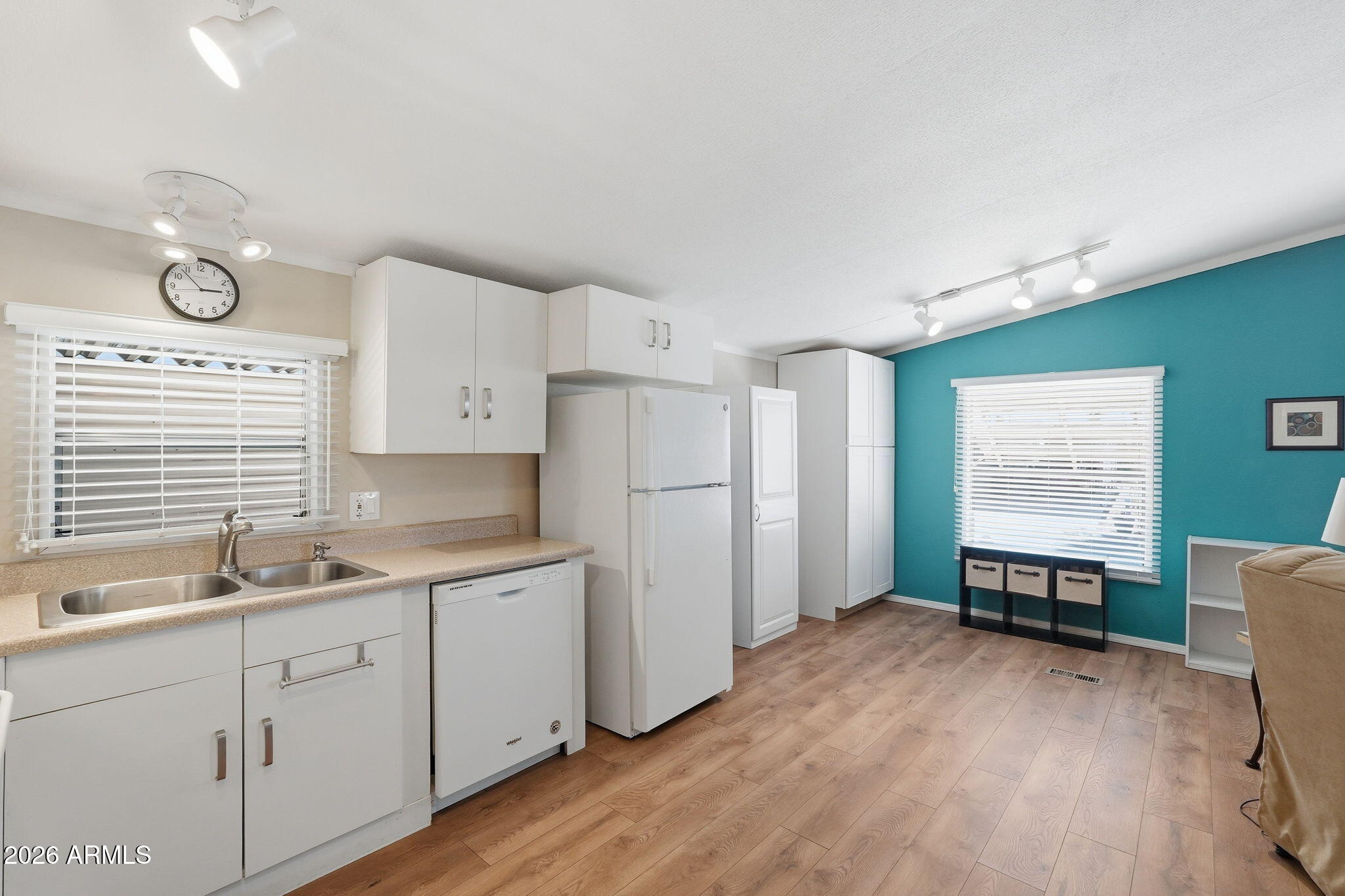53 North Mountain Road, Unit 38 Apache Junction, AZ 85120 - Photo 12 of 35 a kitchen with white cabinets and wooden floors
