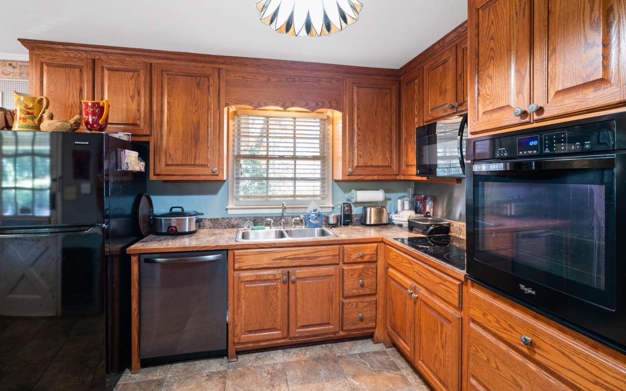 3805 Hilldale Road Oakwood, GA 30566 - Photo 6 of 28 a kitchen with stainless steel appliances granite countertop a stove a sink and a microwave