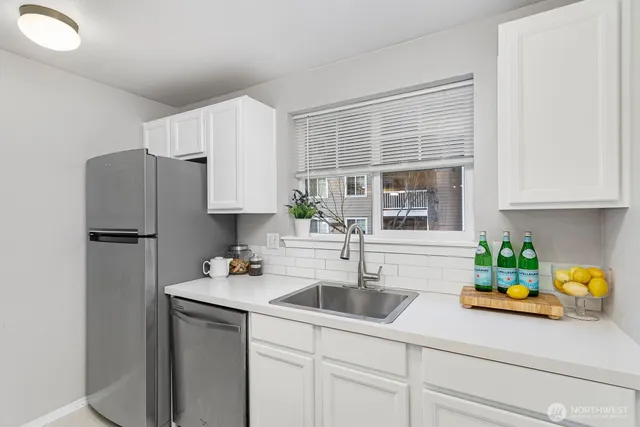 a kitchen with sink a refrigerator and cabinets