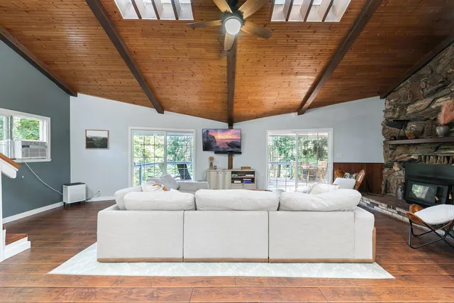 a living room with furniture a flat screen tv and a large window