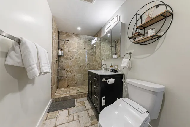 a bathroom with a toilet a sink and mirror